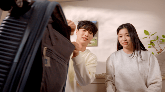 Couple packing travel luggage in living room