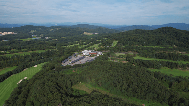 Aerial view of a golf course surrounded by lush forests