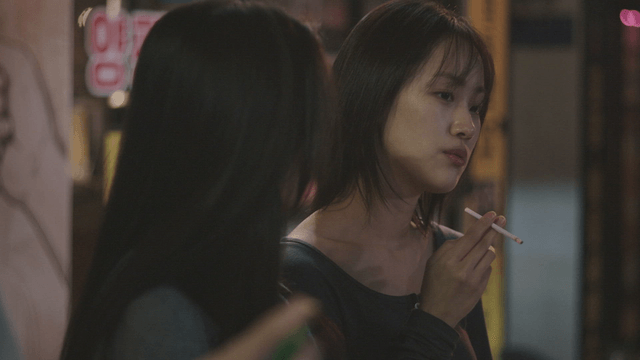 Two women talking while smoking outside