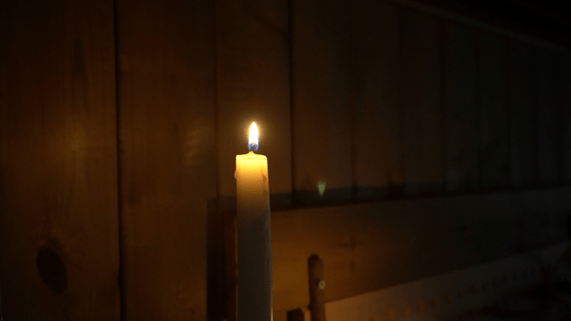 Candle flame burning in a dark room