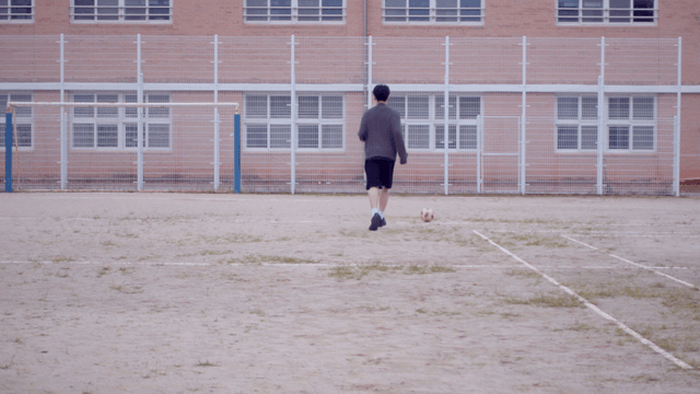 학교 운동장에서 축구하는 사람