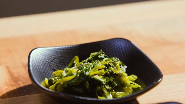 Seasoned spinach in a black dish