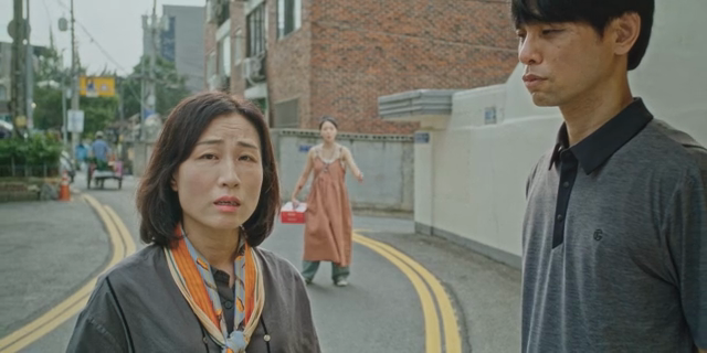 거리에서 대화하는 남녀 뒤에서 소리치는 여성
