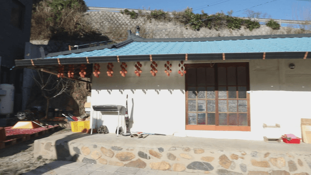 Blue-roofed rural hanok with dried persimmons