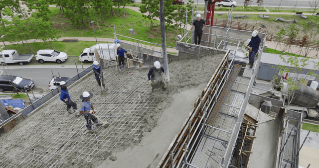 Construction workers pouring concrete on site