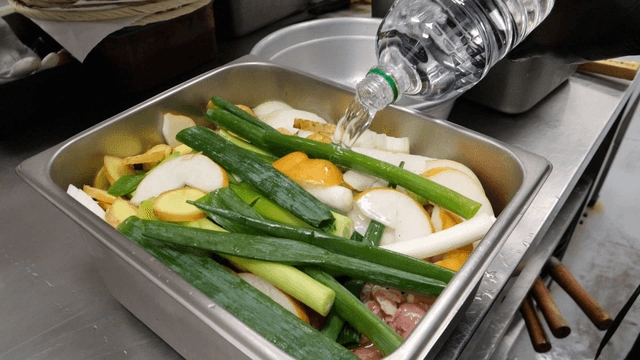 Water poured into tray with vegetables and meat