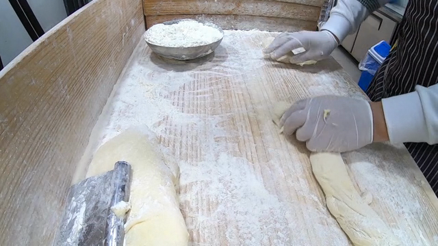 Hands kneading dough on a floured surface