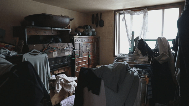 Cluttered room with clothes and furniture