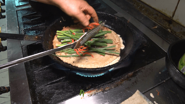 Green onion pancake being cooked in a pan