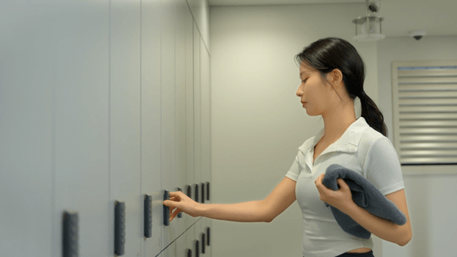 Young woman using a locker in a gym changing room