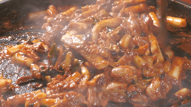 Spicy stir-fried chicken cooking in a pan