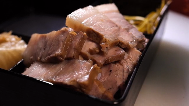 Sliced pork belly in a black tray