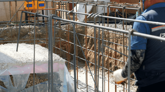 Construction worker handling rebar at site