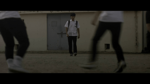 Student walking among students playing soccer on school field