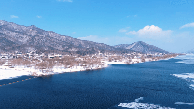 산을 배경으로 한 눈 덮인 강변
