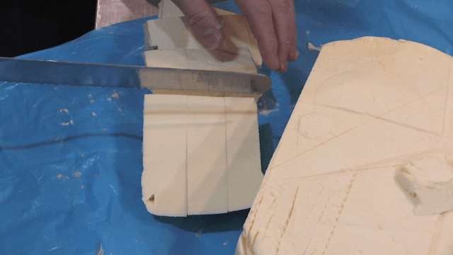Butter being cut on blue countertop