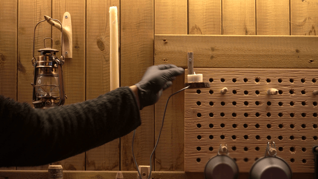 Artisan placing a candle on a wooden wall in the workshop
