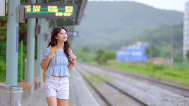 기차역에서 기다리는 젊은 여성