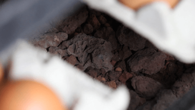 Egg tray with eggs against stone background