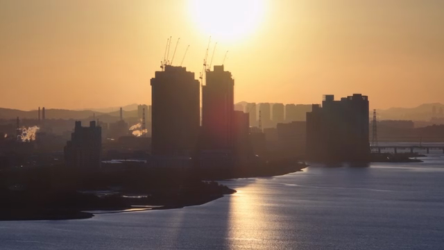 Sunset over a city skyline with river