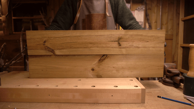 Carpenter organizing wooden boards in workshop