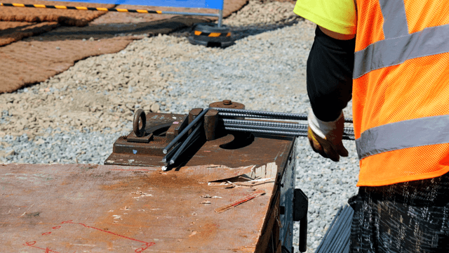 Construction worker bending metal rods