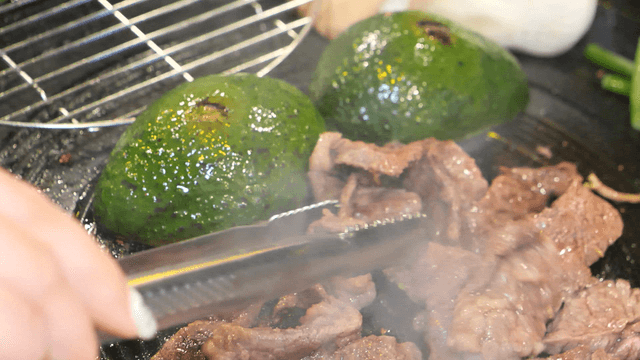 Grilled meat and avocado on a hot iron plate