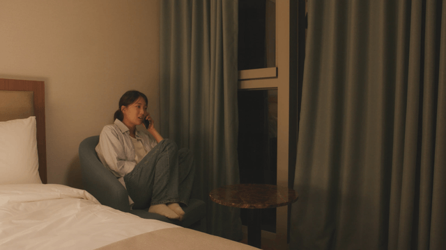 Woman sitting in a room talking on phone