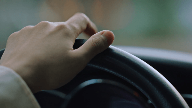 Hand gripping a steering wheel