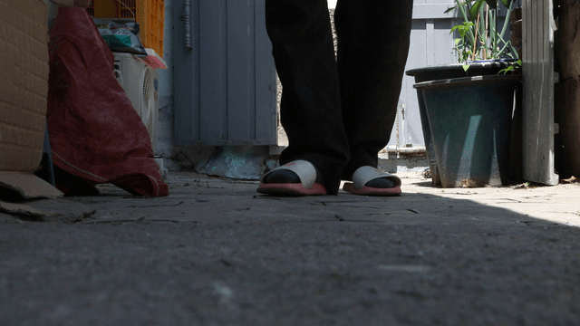 Person walking in a narrow yard