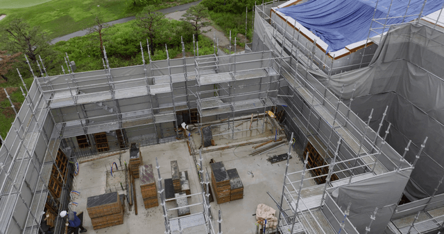 Construction site with scaffolding and greenery