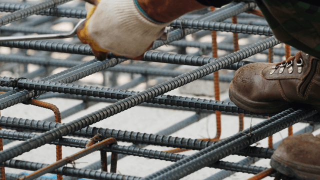 Worker tying rebar at a construction site