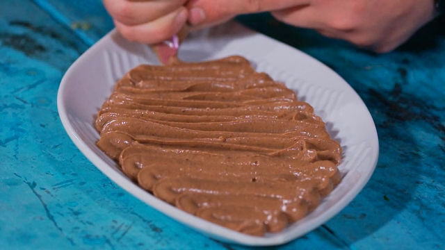 Chocolate mousse being piped onto a plate