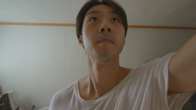 Man looking up and reaching out his hand in a room