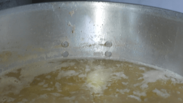 Strainer lifting vegetables from a pot of broth
