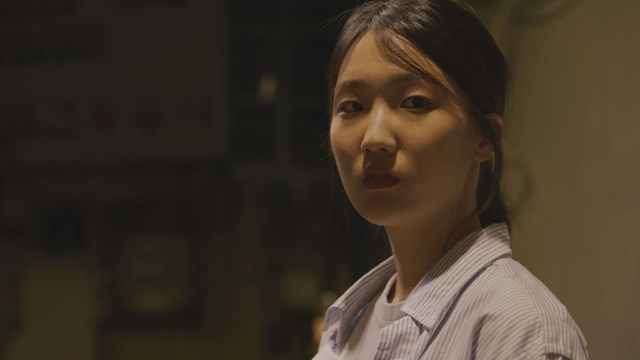 Woman standing under a streetlight at night