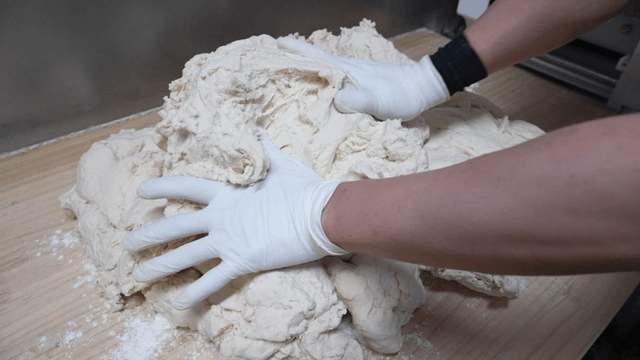 나무 도마 위에 반죽을 올리는 손
