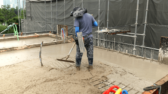 Worker smoothing concrete on a building site