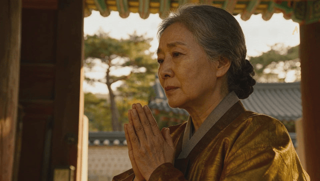 Elder woman in hanbok praying at a temple entrance