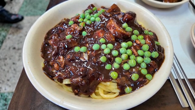 A bowl of jajangmyeon with peas