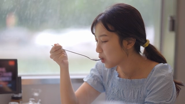 여성이 식당에서 뜨거운 식사를 즐기는 모습