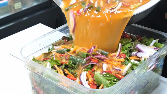 Pouring sauce over assorted vegetables