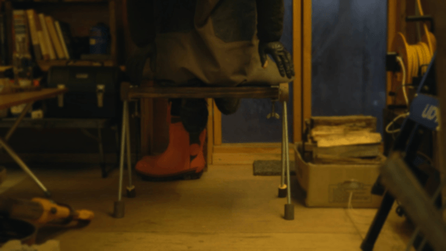 Artisan checking the strength of a handcrafted wooden bench