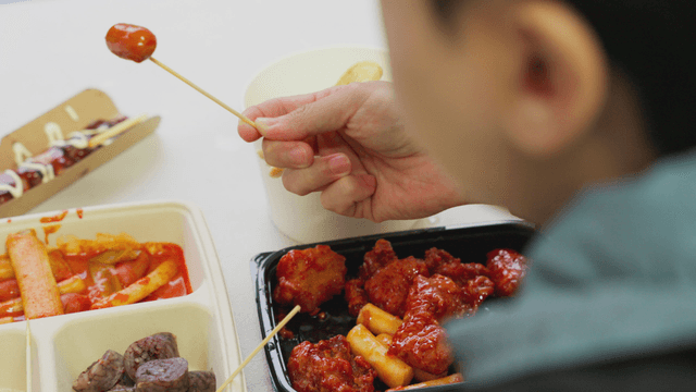 Person enjoying Korean street foods
