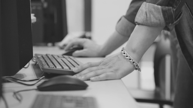 Hands typing on a keyboard in an office