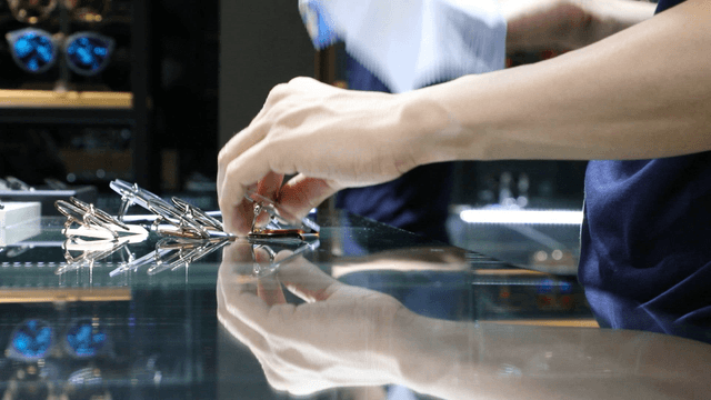 Person cleaning glasses from a display case