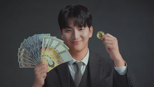 Man smiling at the Bitcoin in his hand