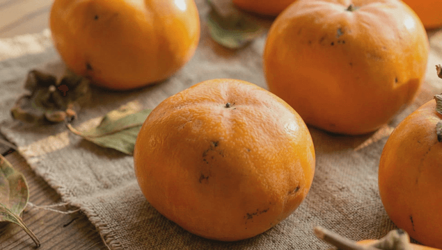 Fresh persimmons on a rustic cloth