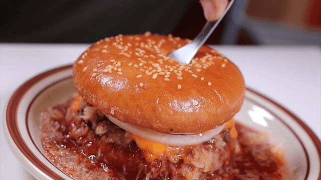 A fork piercing a juicy hamburger