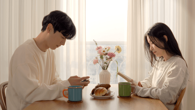 Couple enjoying morning reading or using smartphone
